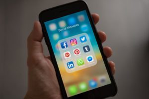 picture of a phone showing social media app icons for an article about organic social media traffic